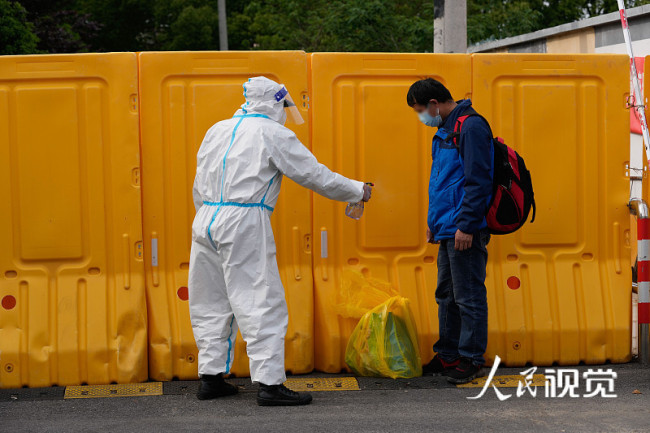 2022年5月1日，上海市闵行区梅陇镇曹行村增设冲淋房，让出舱人员回家更安心。工作人员对出舱人员衣物进行消杀。