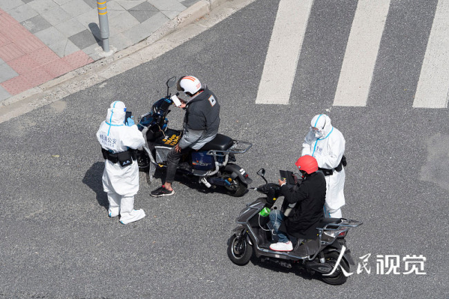 上海交警加强街面巡查,查验通行证及核酸证明。