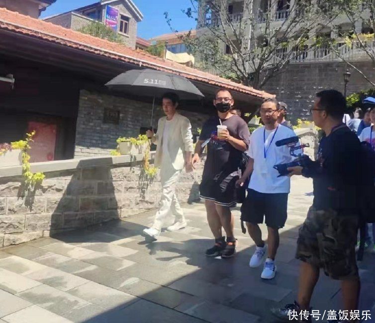 朱一龙现身武汉昙华林，获近十人护送，烈日炎炎让专人帮其系鞋带